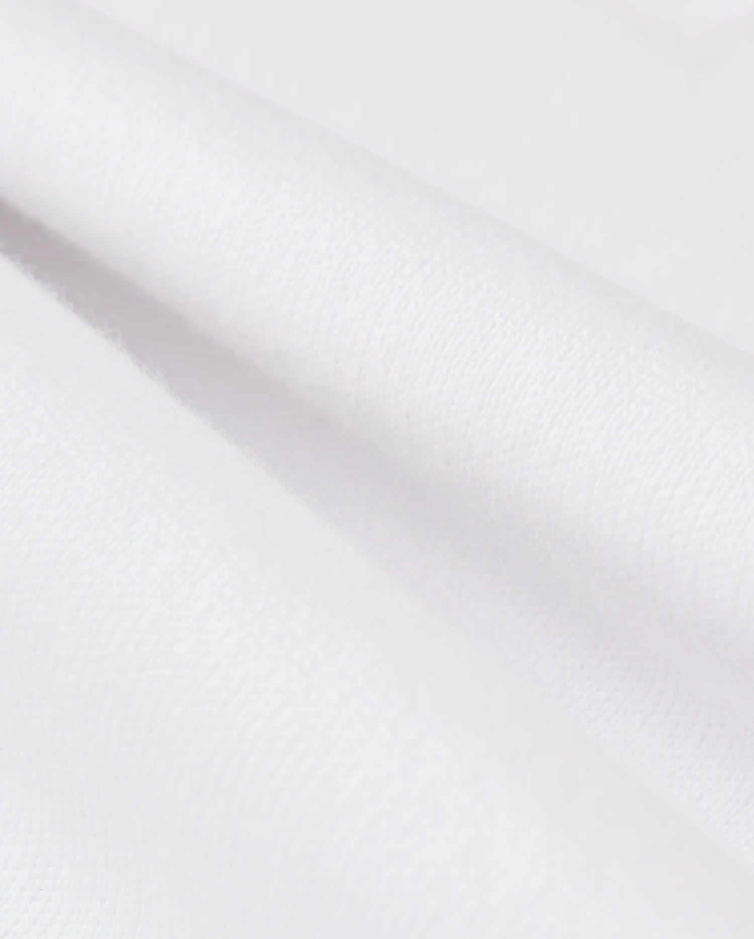Close-up of smooth, white Pima cotton with soft folds, highlighting the clean texture of a Psycho Bunny KIDS LONDON RAGLAN GRAPHIC TEE - B0U896D200.