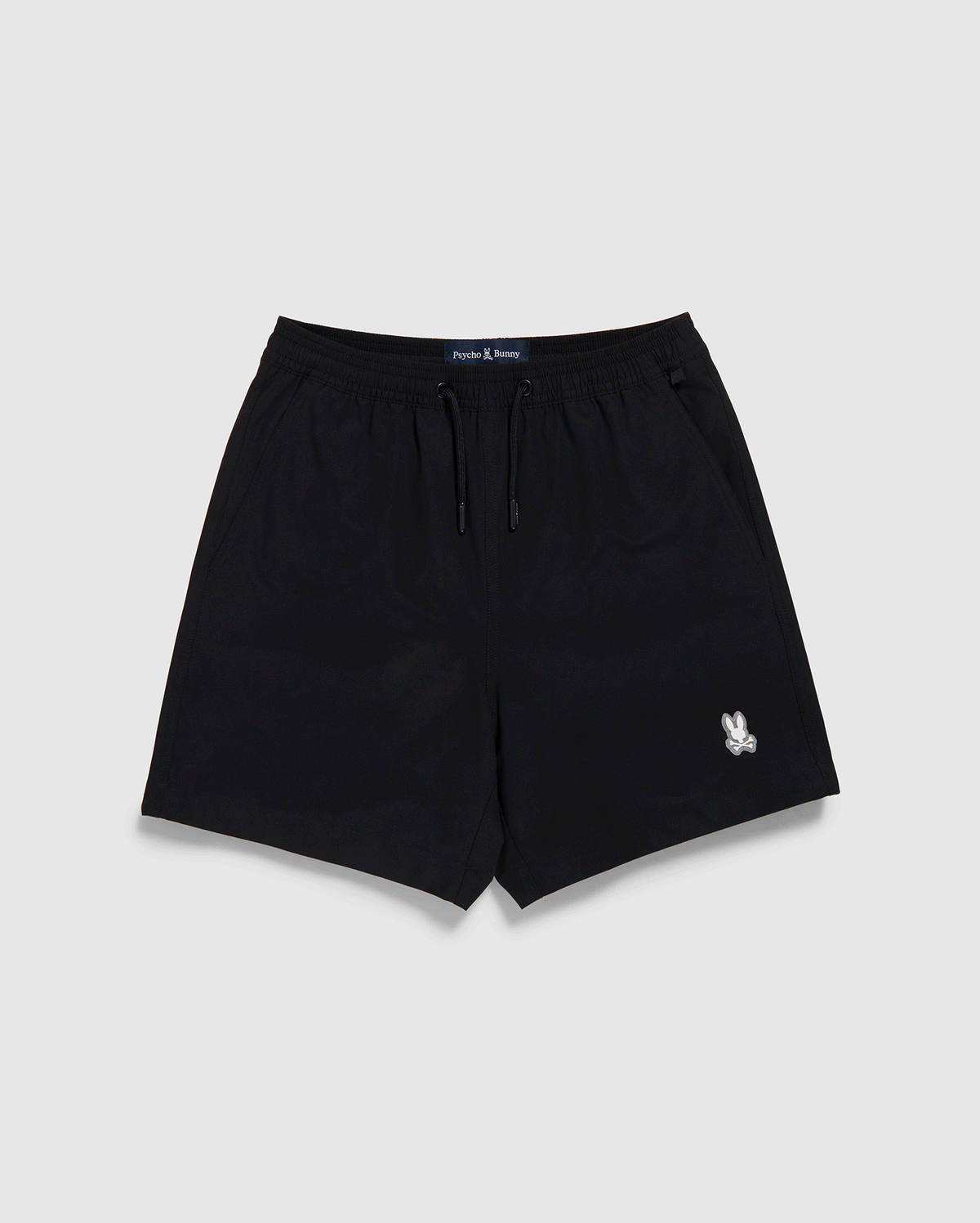 Black Psycho Bunny polyester mechanical stretch shorts with a drawstring waist and a small white logo on the left leg, displayed against a plain white background.