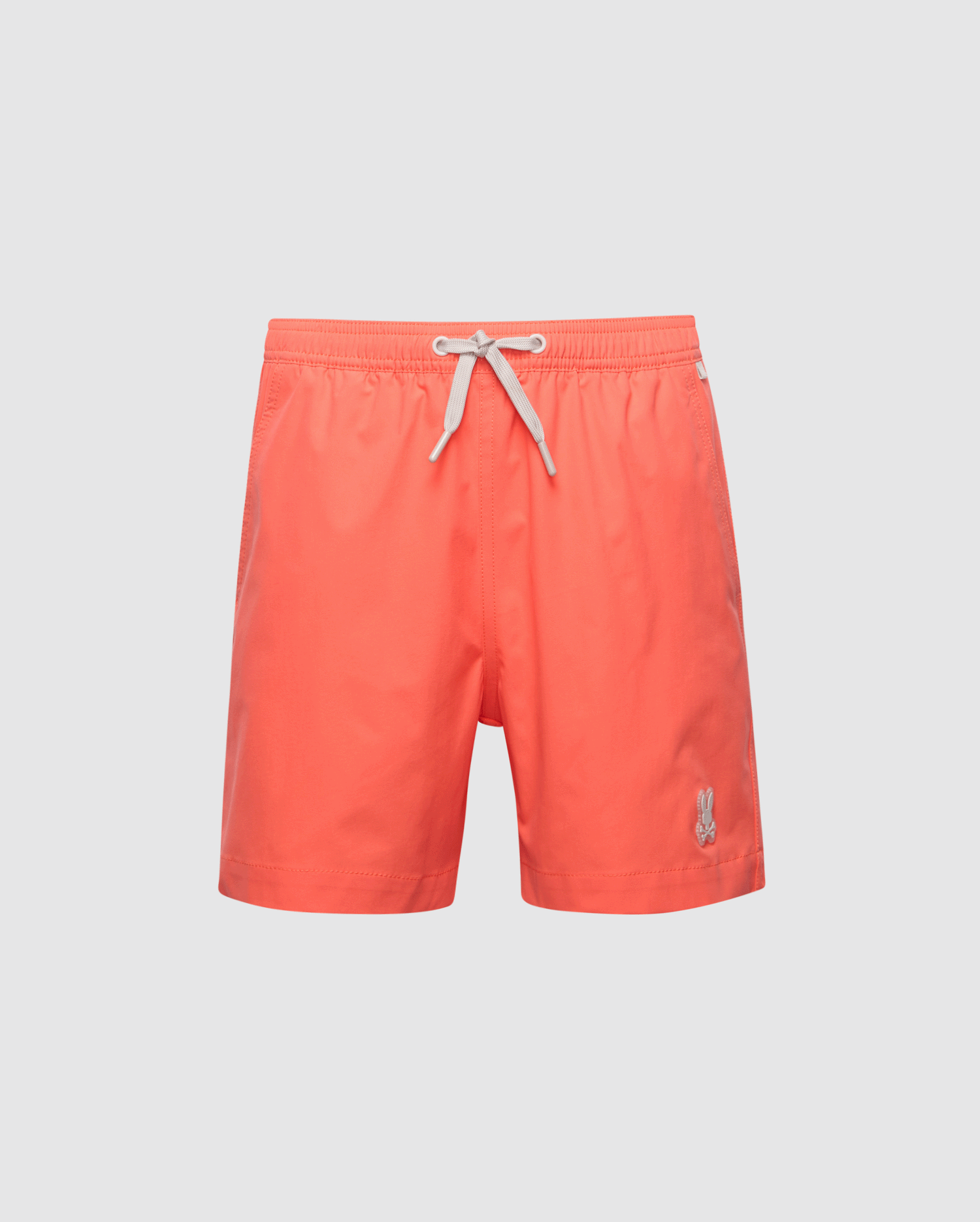 The Psycho Bunny KIDS SAMOS HYDROCHROMIC SWIM TRUNK - B0W453F200 features bright coral color, a white drawstring waistband, and an embroidered logo on the lower left. These quick-dry swim trunks offer a classic design perfect for the beach or pool.