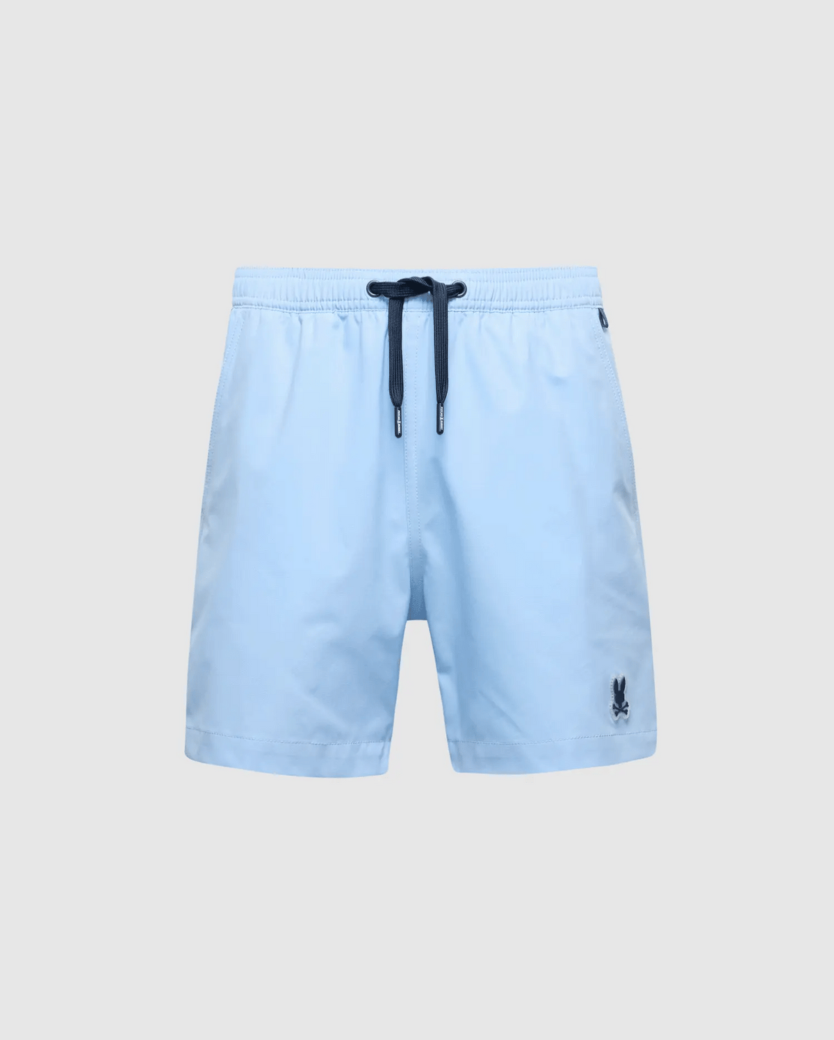 Psycho Bunny's KIDS SAMOS HYDROCHROMIC PRINTED SWIM TRUNK - B0W453F200 features light blue fabric with a dark drawstring waistband, hydrochromic technology, and a small embroidered logo on the lower left side, offering a stylish contrast against any plain gray background.