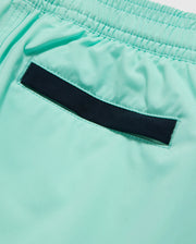 Close-up of the back pocket of a pair of light turquoise, quick-dry swim trunks with an elastic waistband. The pocket has a horizontal black detail running across the top edge. The fabric appears to be smooth and lightweight, perfect for staying comfortable all day. These are the Psycho Bunny KIDS PARKER HYDROCHROMIC SWIM TRUNK - B0W646C200.