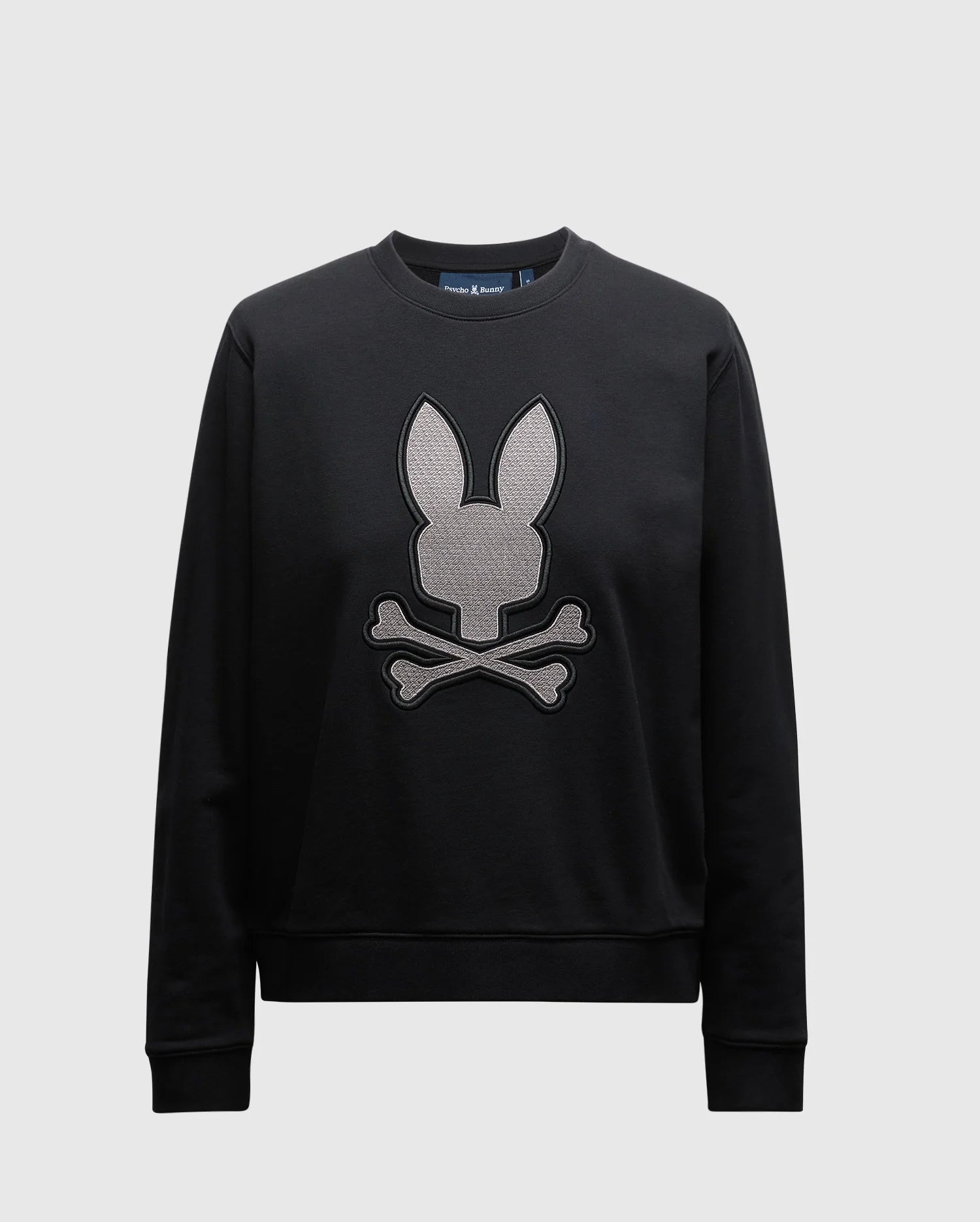 The WOMENS ALEXANDER SWEATSHIRT - B2S156E200 by Psycho Bunny is a black cotton blend knit crew sweatshirt for women, displaying a large, embroidered lurex bunny head above two crossed bones on the front. It features a round neckline and long sleeves set against a plain background.