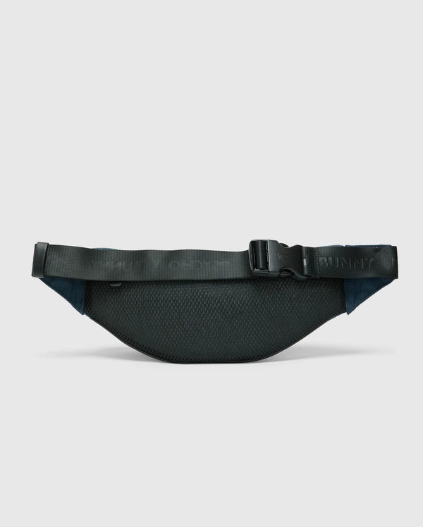 A black nylon MENS CROSS BODY BAG - B6A181E200 by Psycho Bunny features a textured surface with an adjustable strap and buckle. The functional waist bag is displayed against a light gray background.