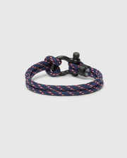 The Psycho Bunny Men's Rope Bracelet - B6A368E200 features a stylish braided dark blue nylon cord with red and white accents and a black metal clasp, offering a modern nautical-inspired look that's perfect for men.