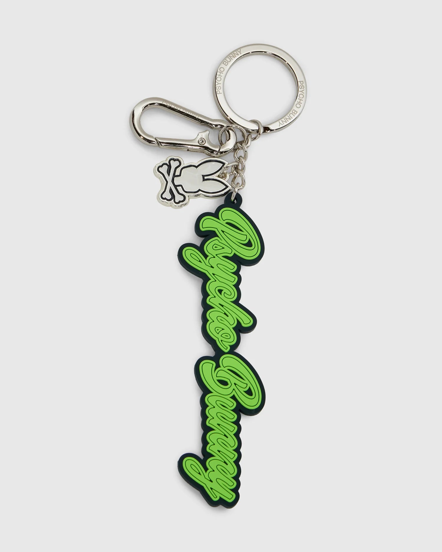 This Psycho Bunny silicone keychain, model B6A373E200, displays the text "Angels Bunny" in elegant green script on a silver keyring with a lobster clasp. It includes an extra charm of a bunny outline, combining practicality with a chic design.