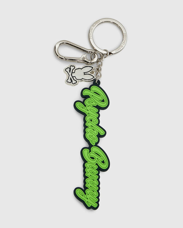 This Psycho Bunny silicone keychain, model B6A373E200, displays the text "Angels Bunny" in elegant green script on a silver keyring with a lobster clasp. It includes an extra charm of a bunny outline, combining practicality with a chic design.