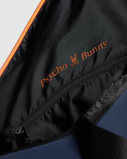 A close-up of the MENS DUFFLE BAG - B6A472F200 reveals the vibrant orange embroidered "Psycho Bunny" logo on its black lining, adorned with a stylish bunny skull design. A gleaming zipper adds a touch of quality craftsmanship.