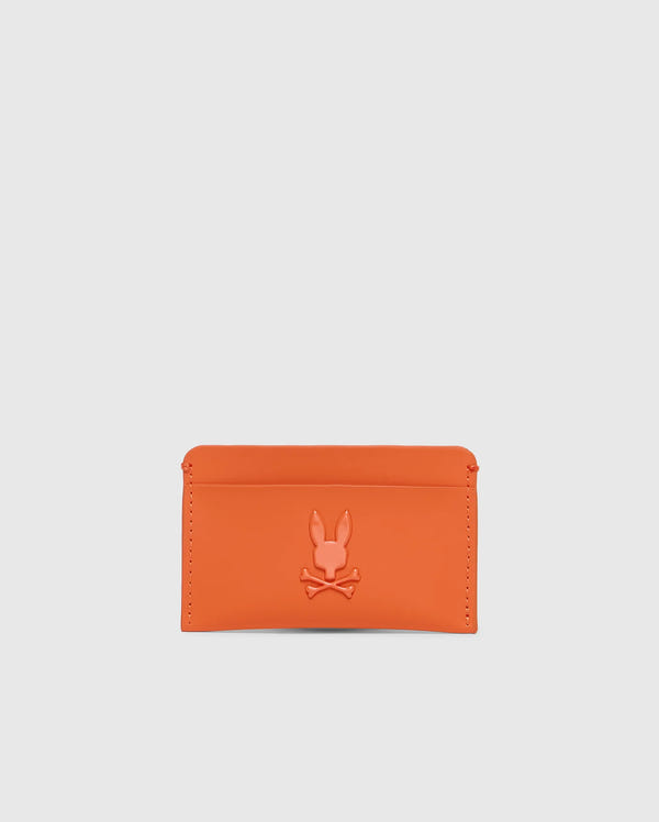 The Psycho Bunny Men's Rubberized Card Case (B6A473F200) in orange features a rabbit and crossbones design embossed on durable polyester. This minimalist card case is stylish, practical, and perfect for safely carrying essentials against a plain white background.