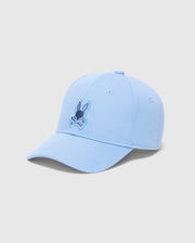 The MENS NEW CASTLE GRAPHIC BASEBALL CAP (B6A547F200) by Psycho Bunny is a light blue cotton twill cap with a rabbit's head and crossbones in darker blue on the front. Set against a plain white backdrop, it captures quiet luxury through its subtle yet striking design.