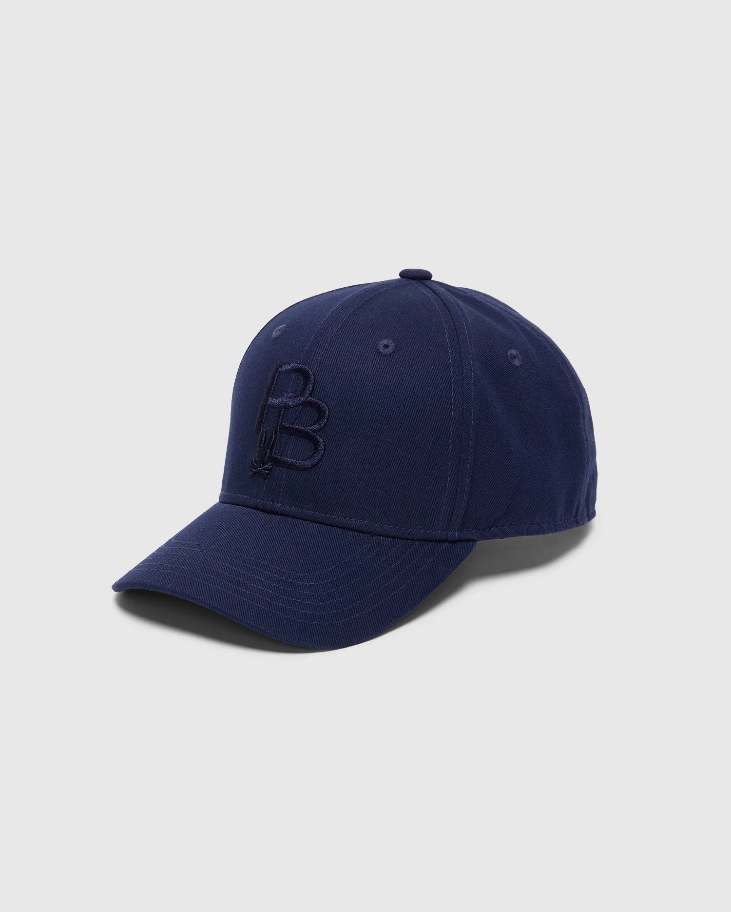 A navy blue cotton twill baseball cap from Psycho Bunny, featuring a curved brim against a light backdrop. The MENS NICHOLSON PB BUNNY GRAPHIC BASEBALL CAP showcases an embroidered "B" on the front and includes an adjustable backstrap for an ideal fit.