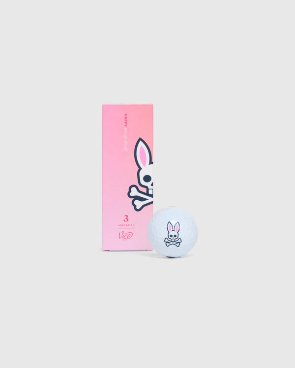 A white golf ball featuring a cartoon skull and crossbones with bunny ears, located next to a pink box on a gray background. The box displays the same bunny skull design and includes text that reads "3" and "Psycho Bunny" with smaller text beneath. This 3 PACK GOLF BALLS - B6A565C200 sleeve is designed to minimize driver spin.