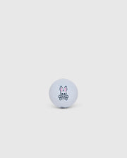 A white golf ball from the Psycho Bunny collection, featuring a simple logo with a cartoon bunny and crossed bones underneath, centered on a plain light gray background. Offered in an elegant golf ball sleeve, the 3 PACK GOLF BALLS - B6A565C200 is designed to minimize driver spin for enhanced performance.