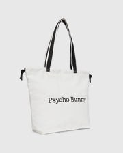 The "TENNIS TOTE - B6A596C200" by Psycho Bunny is a white canvas tote bag with black handles, featuring the text "Psycho Bunny" on the front and an embroidered logo for an elegant touch.
