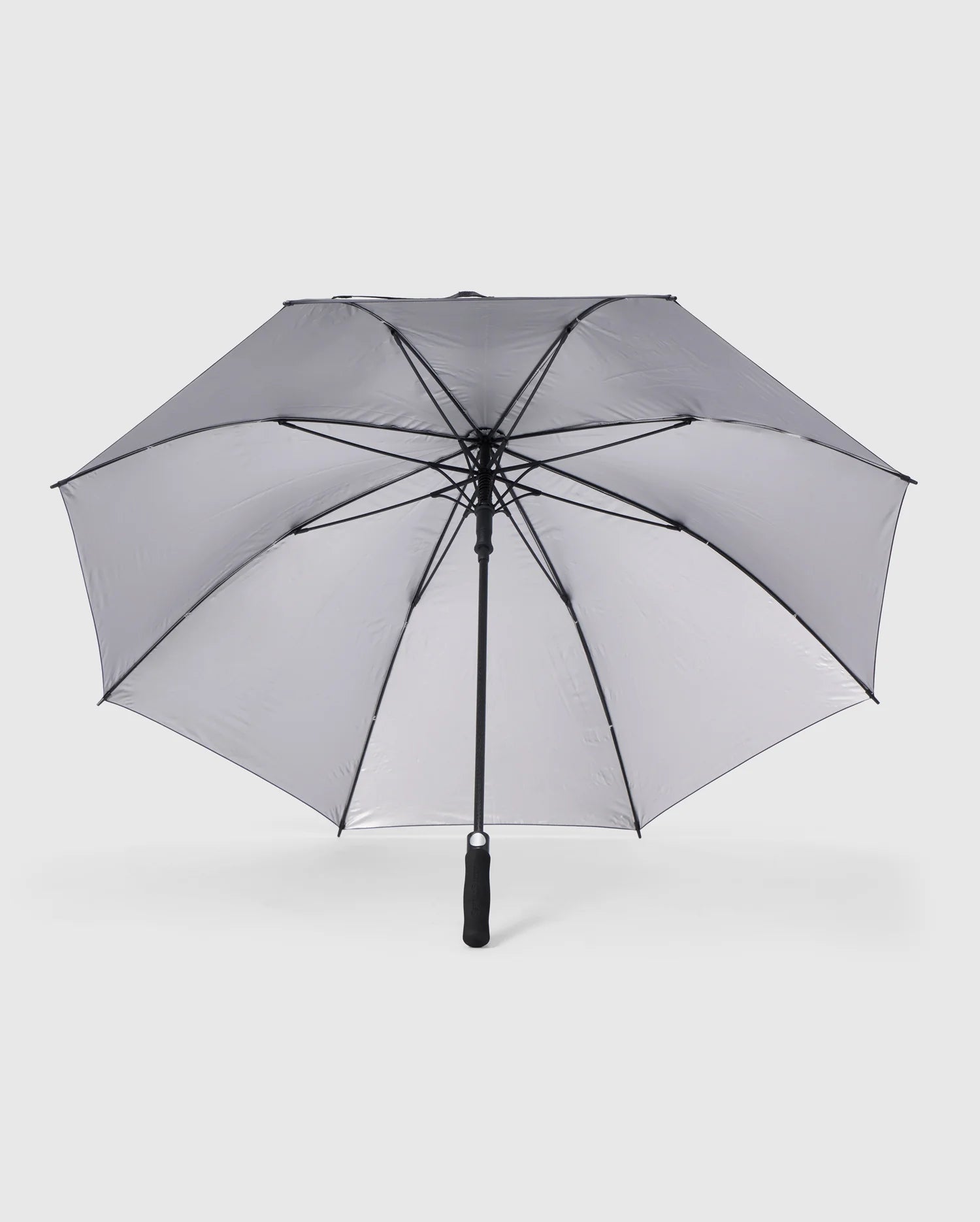 A large, open GOLF UMBRELLA - B6A624C200 from the Psycho Bunny brand features a collapsible design with a black frame and gray canopy. This dependable umbrella has a central black pole and handle, with clearly visible spokes set against a plain white background.