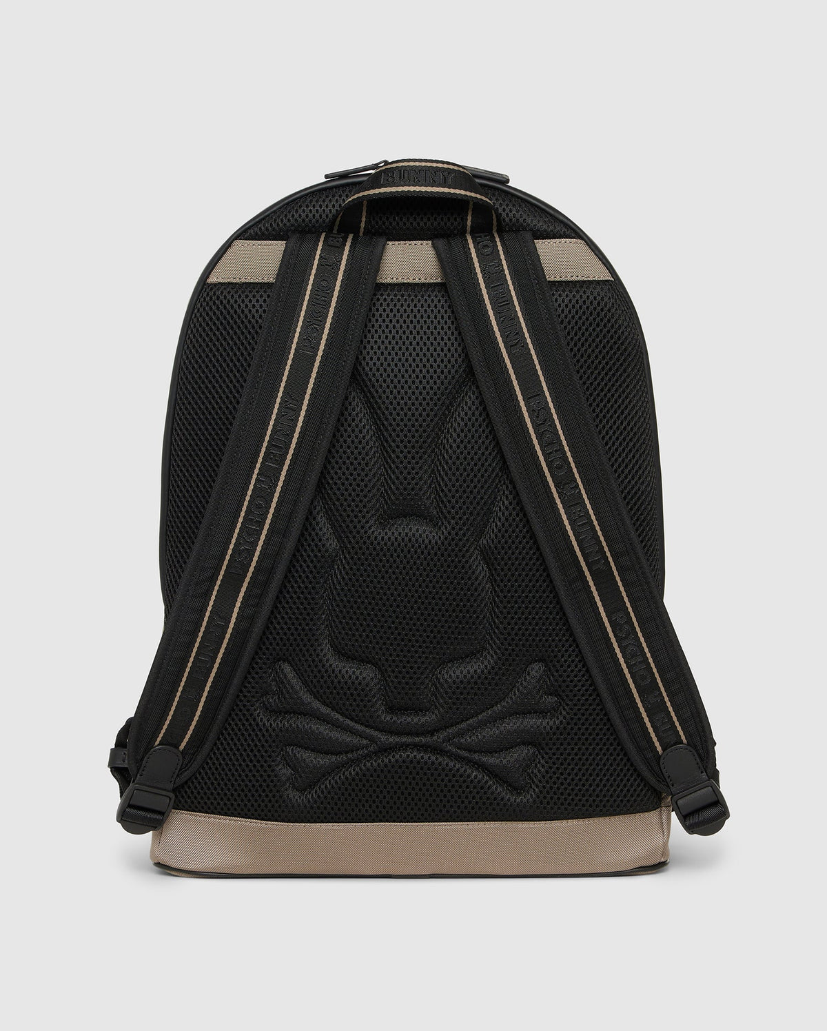A stylish black urban backpack with a subtle rabbit and crossbones design embossed on the back panel. The straps are black with beige accents, and the base is beige. With a sleek, modern appearance and a padded laptop compartment, this Psycho Bunny MENS DOME BACKPACK - B6A628Z1BP blends functionality with unique style seamlessly.