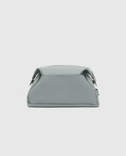 The Psycho Bunny MENS TOILETRY KIT - B6A636F200 is a small, minimalist mint green polyester bag with a sleek finish, structured shape, two side buckles, and a top handle to organize essentials on the go against a light gray background.
