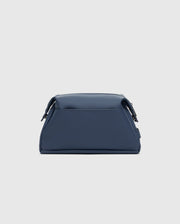 The Psycho Bunny Mens Toiletry Kit, B6A636F200, features a structured design in blue leather with silver hardware accents against a light gray background, perfect for organizing essentials on the go.