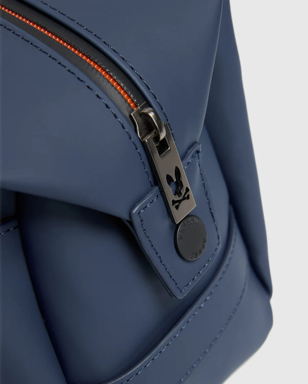 Close-up of the Psycho Bunny MENS TOILETRY KIT - B6A636F200 in blue, crafted from 100% polyester. It features a black zipper with orange teeth, equipped with a round black pull tab adorned with a small rabbit logo to keep your essentials organized on the go.