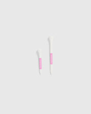 The image features two white tubes set against a light gray background, each with a pink label. The smaller tube is positioned on the left and is decorated with Psycho Bunny's 75 PACK GOLF TEES - B6A659C200, accented by bunny-themed designs. The larger tube is on the right, ideal for those looking for whimsical golf accessories from the Psycho Bunny brand.