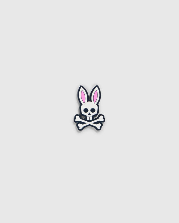 A graphic of a bunny skull and crossbones from the Psycho Bunny golfers collection. The skull has rabbit ears with pink interiors and a small bow tie under the chin. Crossbones form an "X" below the skull, perfect as the Psycho Bunny BALL MARKER - B6A698C200 with its playful design on a plain, light gray background.