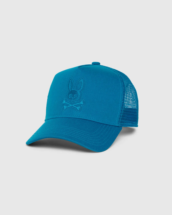 The MENS MALTON TRUCKER CAP - B6A797D200 by Psycho Bunny is a blue trucker cap featuring mesh ventilation, a solid front panel with an embroidered bunny skull and crossbones logo, and a curved brim for added style. The cap is made of 100% cotton.