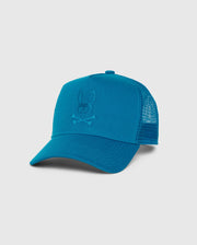 The MENS MALTON TRUCKER CAP - B6A797D200 by Psycho Bunny is a blue trucker cap featuring mesh ventilation, a solid front panel with an embroidered bunny skull and crossbones logo, and a curved brim for added style. The cap is made of 100% cotton.