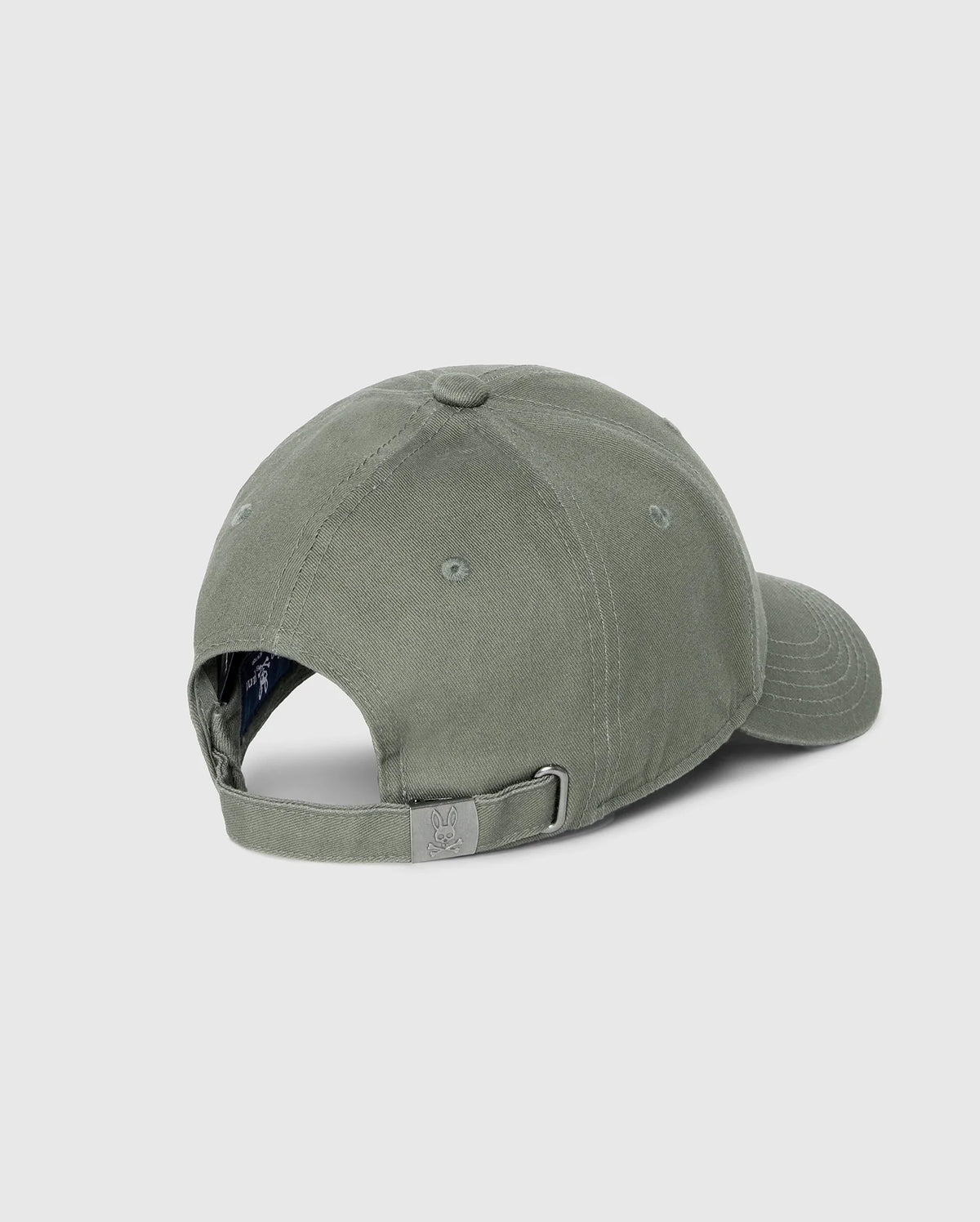 The Psycho Bunny MENS CLASSIC BASEBALL CAP - B6A816B200, crafted from 100% cotton in a solid pattern, is shown from the back with an adjustable strap and metal buckle against a light gray background.