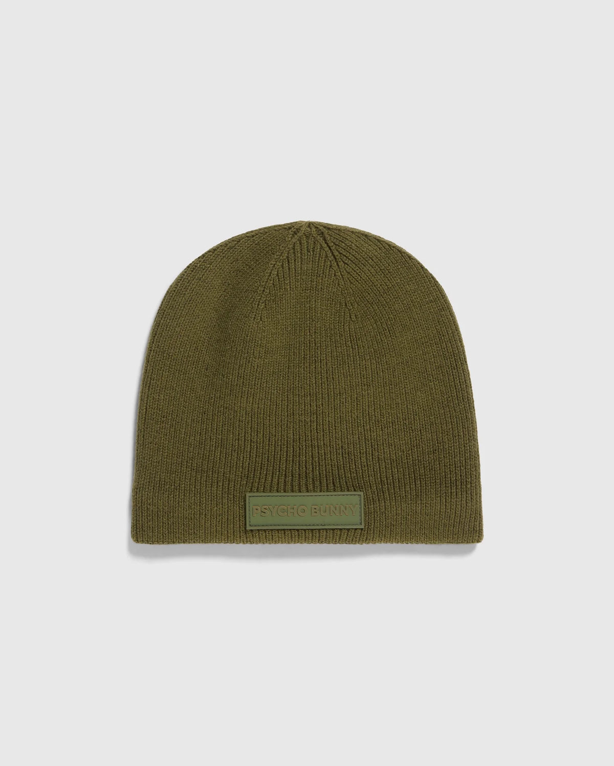 The MENS SPORT BEANIE - B6A874D200 by Psycho Bunny is a premium olive green knitted hat made from merino wool, featuring a small rectangular "Psycho Bunny" patch on the front. It is showcased against a light gray background, emphasizing its high-performance quality.