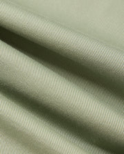 Close-up of the Psycho Bunny MENS BRENDAN JERSEY SHIRT - B6C749D200, featuring a green-striped Pima cotton fabric that displays fine diagonal lines and gentle folds. The material showcases a textured pattern with a smooth appearance, offering a subtle interplay of light and shadow.