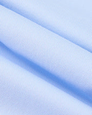 A close-up of the MENS BRENDAN JERSEY SHIRT - B6C749D200 by Psycho Bunny reveals a light blue and white striped fabric with diagonal lines that create a soft, textured appearance. Made from high-quality Pima cotton, the neatly folded shirt highlights its smooth and durable weave.