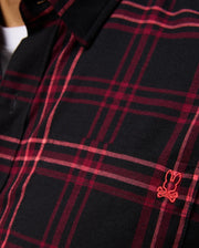 A detailed view of the MENS HAYES PLAID SHIRT - B6C842D200 by Psycho Bunny, showcasing a red plaid design on a black button-down shirt with a small embroidered red bunny logo on the chest, made from soft Pima cotton.