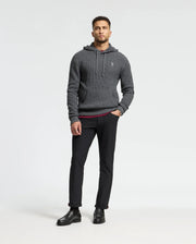 A man in a Psycho Bunny dark gray MENS LEVAN WAFFLE HOODED SWEATER, black pants, and shoes stands against a plain white background. He has short hair and is looking directly at the camera.