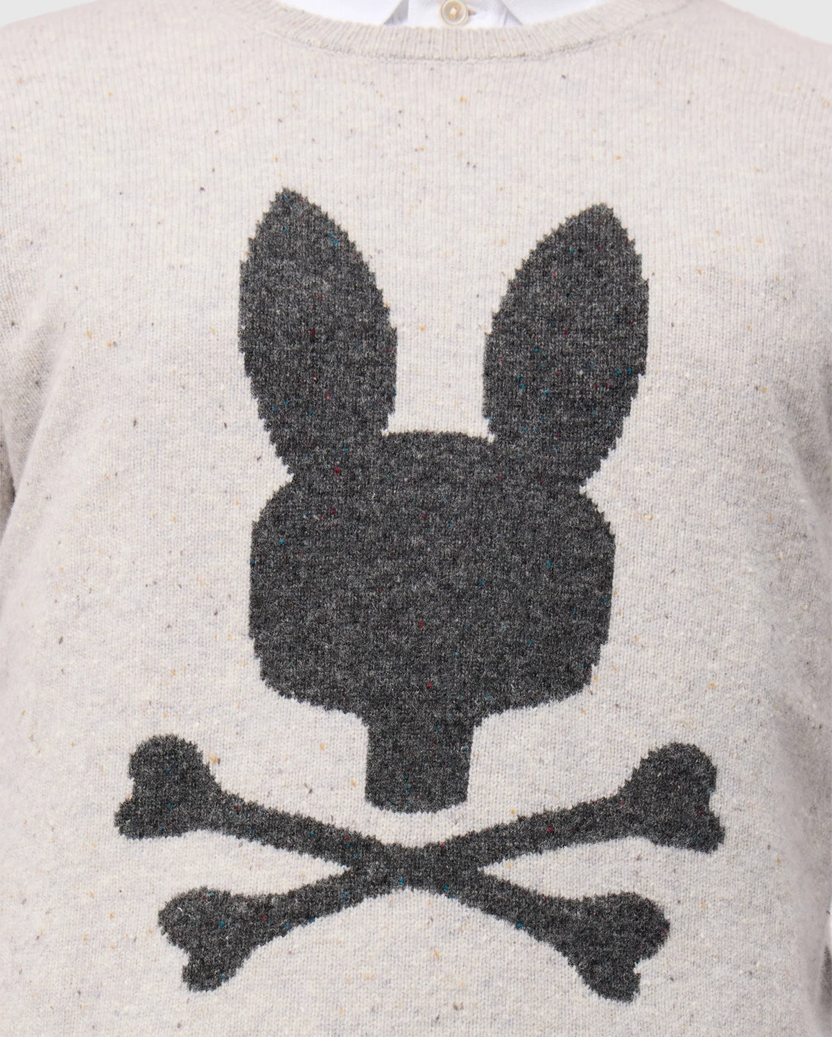 Here’s an up-close look at the Psycho Bunny MENS LINCOLN MERINO WOOL SWEATER (B6E831D200), offering a timeless style with its soft merino wool construction. It showcases a large, dark gray silhouette of a bunny's head with long ears, playfully mimicking the classic skull and crossbones design by featuring two crossed bones beneath it.
