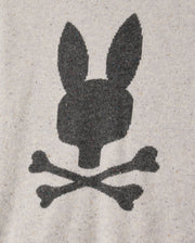The Psycho Bunny Mens Lincoln Merino Wool Sweater (B6E831D200) features a black silhouette of a rabbit head with long ears above two crossed bones, akin to a skull and crossbones design, printed on a heather gray fabric background, offering a timeless style crafted from luxurious merino wool.