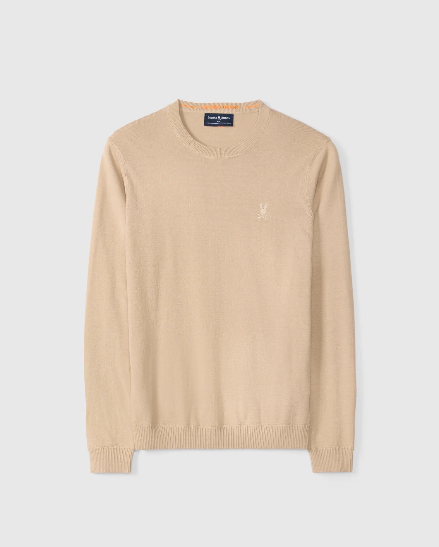 The Psycho Bunny "Mens Belmore Extra Fine Cotton Sweater - B6E832D200" is made from extrafine cotton with a beige long-sleeve crew neck. It features the embroidered Bunny logo on the left chest, ribbed cuffs, and hem, all on a plain white background.