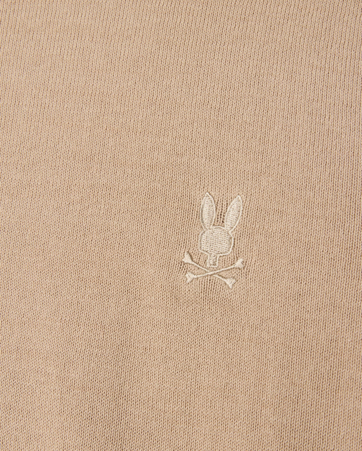 The Psycho Bunny beige Belmore sweater (B6E832D200) is crafted from extrafine cotton and features an embroidered Bunny logo with a skull and crossbones motif, complete with rabbit ears.