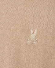 The Psycho Bunny beige Belmore sweater (B6E832D200) is crafted from extrafine cotton and features an embroidered Bunny logo with a skull and crossbones motif, complete with rabbit ears.