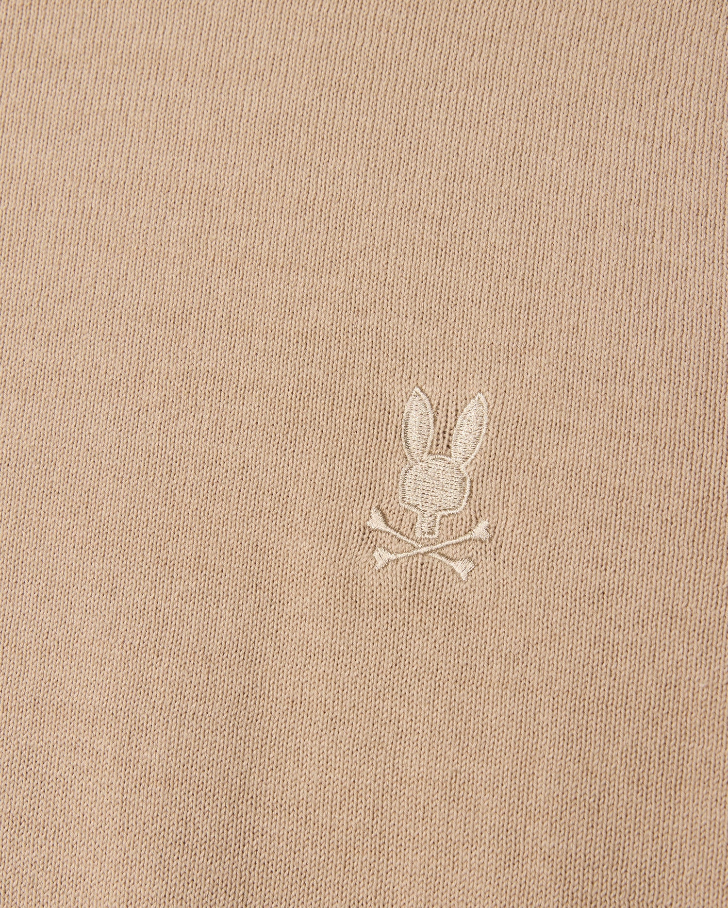 The Psycho Bunny beige Belmore sweater (B6E832D200) is crafted from extrafine cotton and features an embroidered Bunny logo with a skull and crossbones motif, complete with rabbit ears.