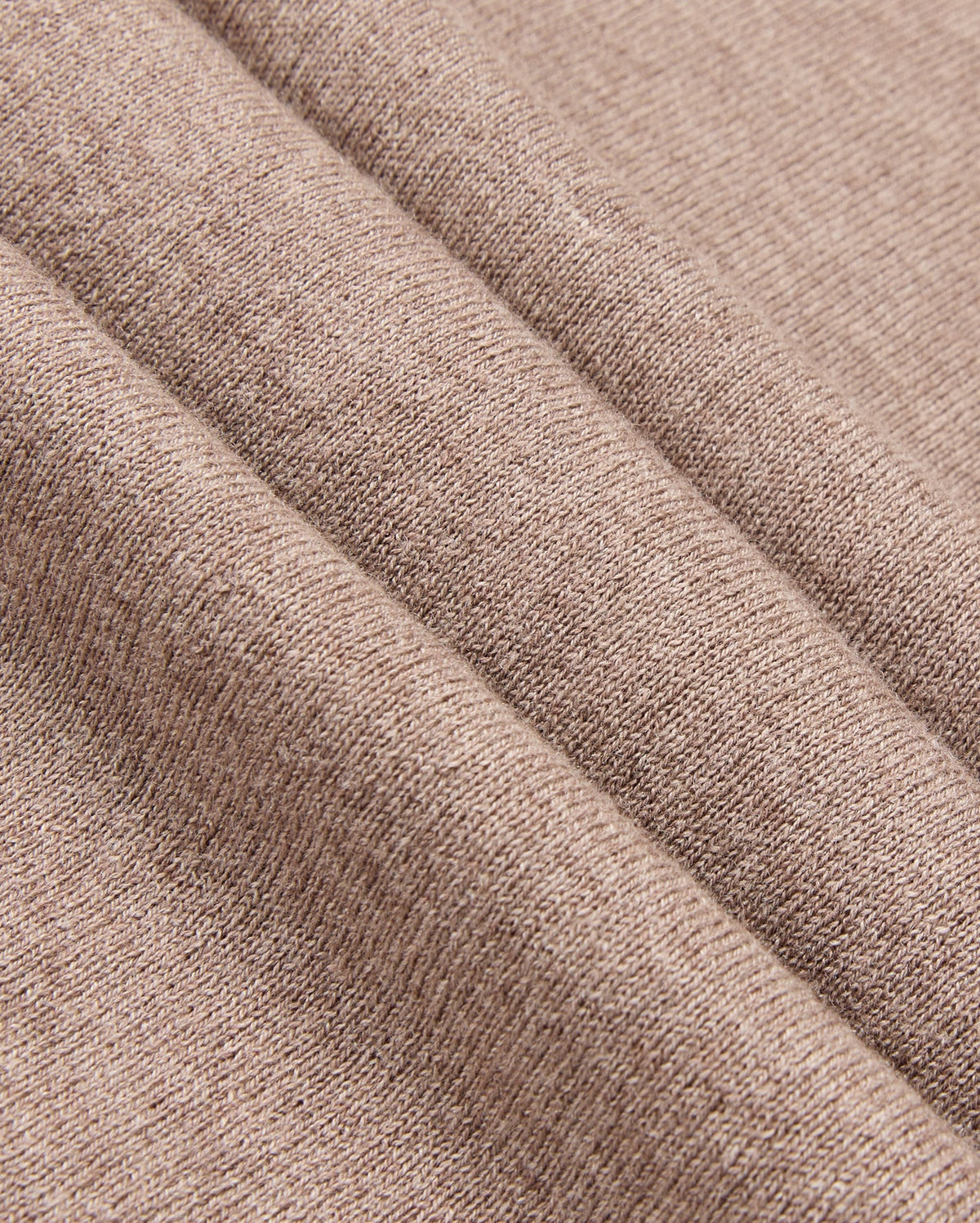 The image features a close-up of the MENS BRADSHAW POLO SWEATER - B6E835D200 by Psycho Bunny, showcasing its soft brown fabric with a diagonal seam. The textile's texture reveals a subtle woven pattern, reminiscent of luxury garments and ideal for clothing or upholstery, giving it a cozy and warm appearance.