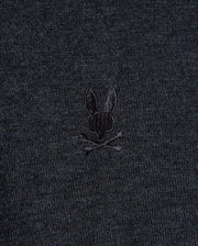 The MENS BRADSHAW POLO SWEATER - B6E835D200 from Psycho Bunny is made from premium merino wool and features a subtle design of a rabbit head with crossed bones, echoing the traditional skull and crossbones motif.