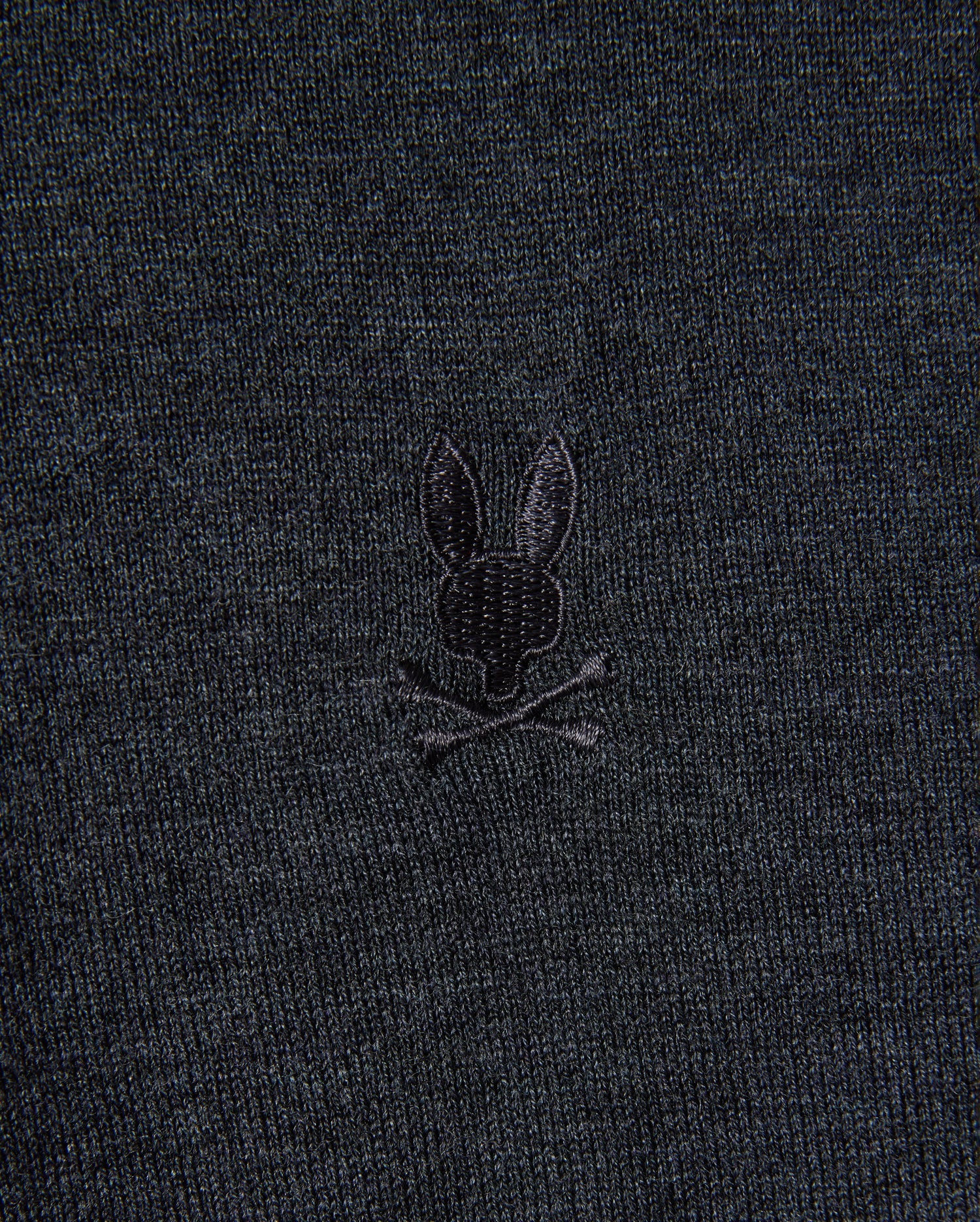 The MENS BRADSHAW POLO SWEATER - B6E835D200 from Psycho Bunny is made from premium merino wool and features a subtle design of a rabbit head with crossed bones, echoing the traditional skull and crossbones motif.