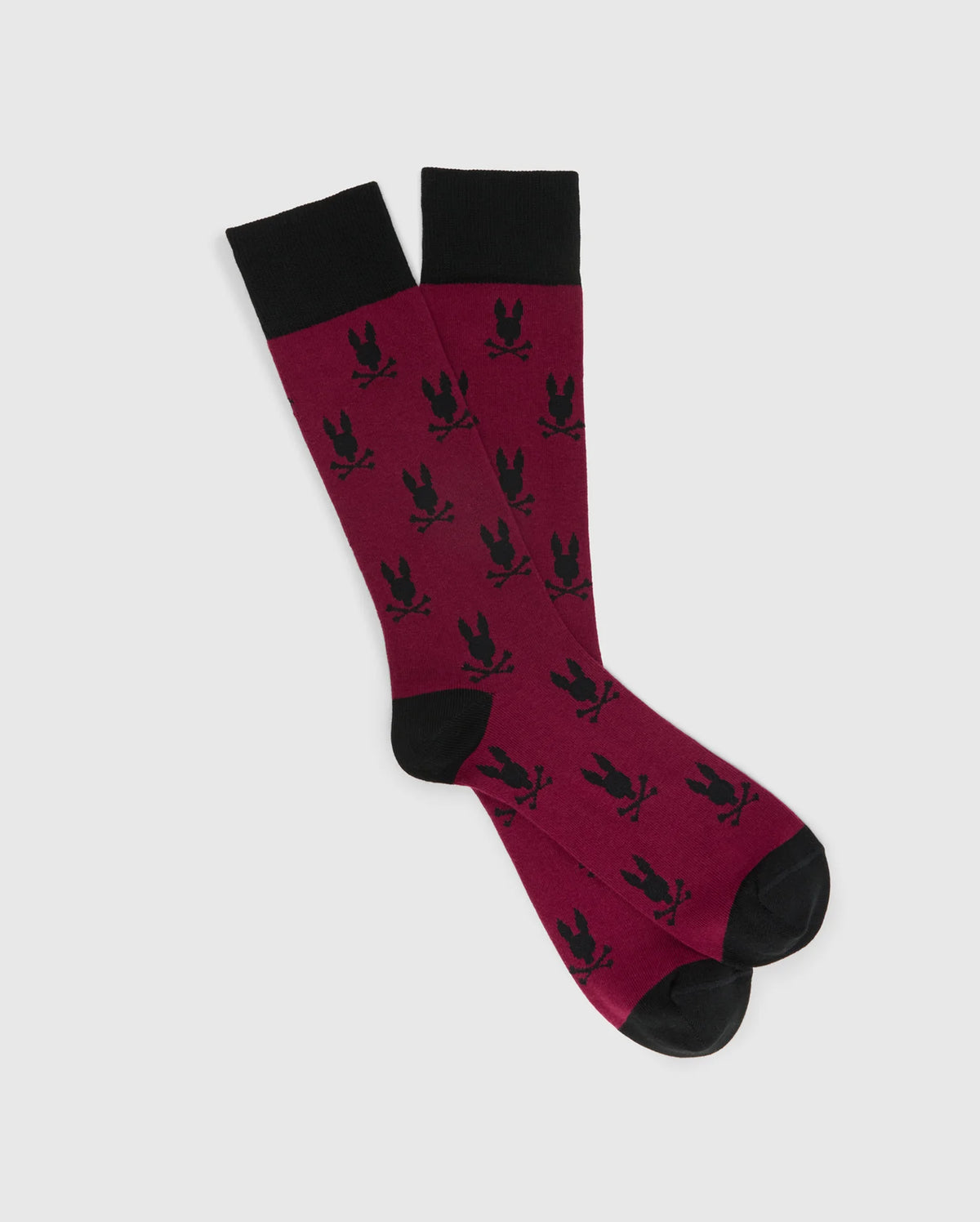The MENS ALL OVER BUNNY DRESS SOCK by Psycho Bunny is expertly crafted from soft Pima cotton, featuring a maroon shade accented with black trim at the top, heels, and toes. This stylish design highlights a striking pattern of black bunny silhouettes.