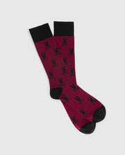 The MENS ALL OVER BUNNY DRESS SOCK by Psycho Bunny is expertly crafted from soft Pima cotton, featuring a maroon shade accented with black trim at the top, heels, and toes. This stylish design highlights a striking pattern of black bunny silhouettes.