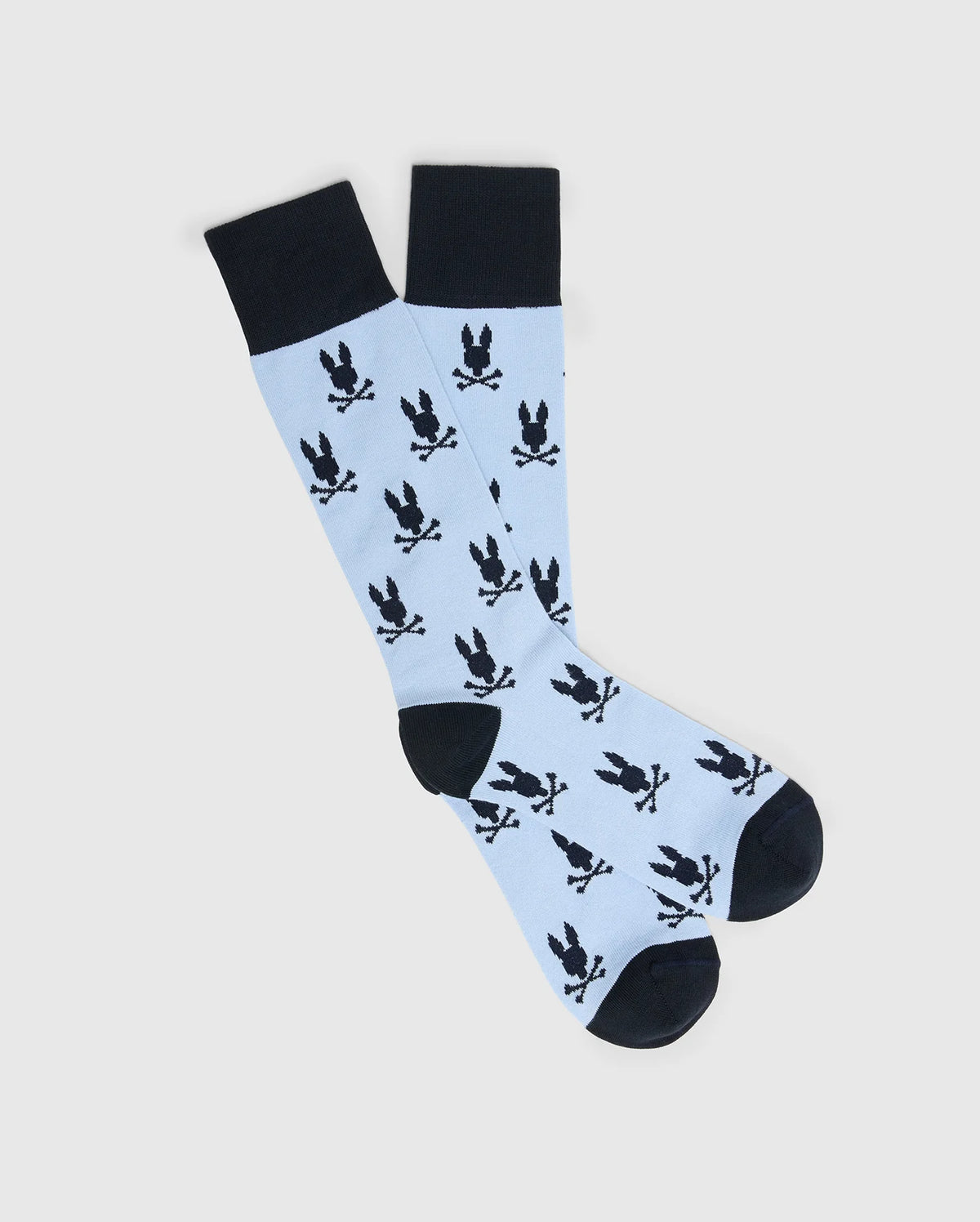 Psycho Bunny's Men's All Over Bunny Dress Sock (B6F750F200) features a playful light blue knee-high design with jacquard-knit black bunnies holding sticks. Made of soft Pima cotton, the socks have solid black toes, heels, and cuffs for a striking contrast to the whimsical pattern.