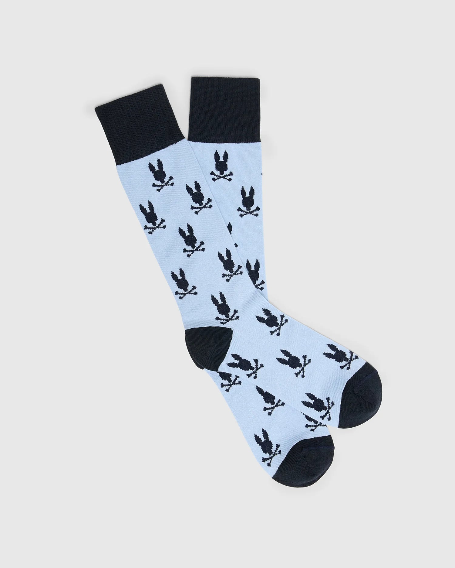 Psycho Bunny's Men's All Over Bunny Dress Sock (B6F750F200) features a playful light blue knee-high design with jacquard-knit black bunnies holding sticks. Made of soft Pima cotton, the socks have solid black toes, heels, and cuffs for a striking contrast to the whimsical pattern.