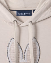 Close-up of the MENS WALTER LIGHTWEIGHT HOODIE - B6H476D200 by Psycho Bunny, crafted from beige Micro French terry. This regular fit hoodie features two drawstrings and an embroidered bunny ear design on the chest area, with the "Psycho Bunny" label sewn inside.