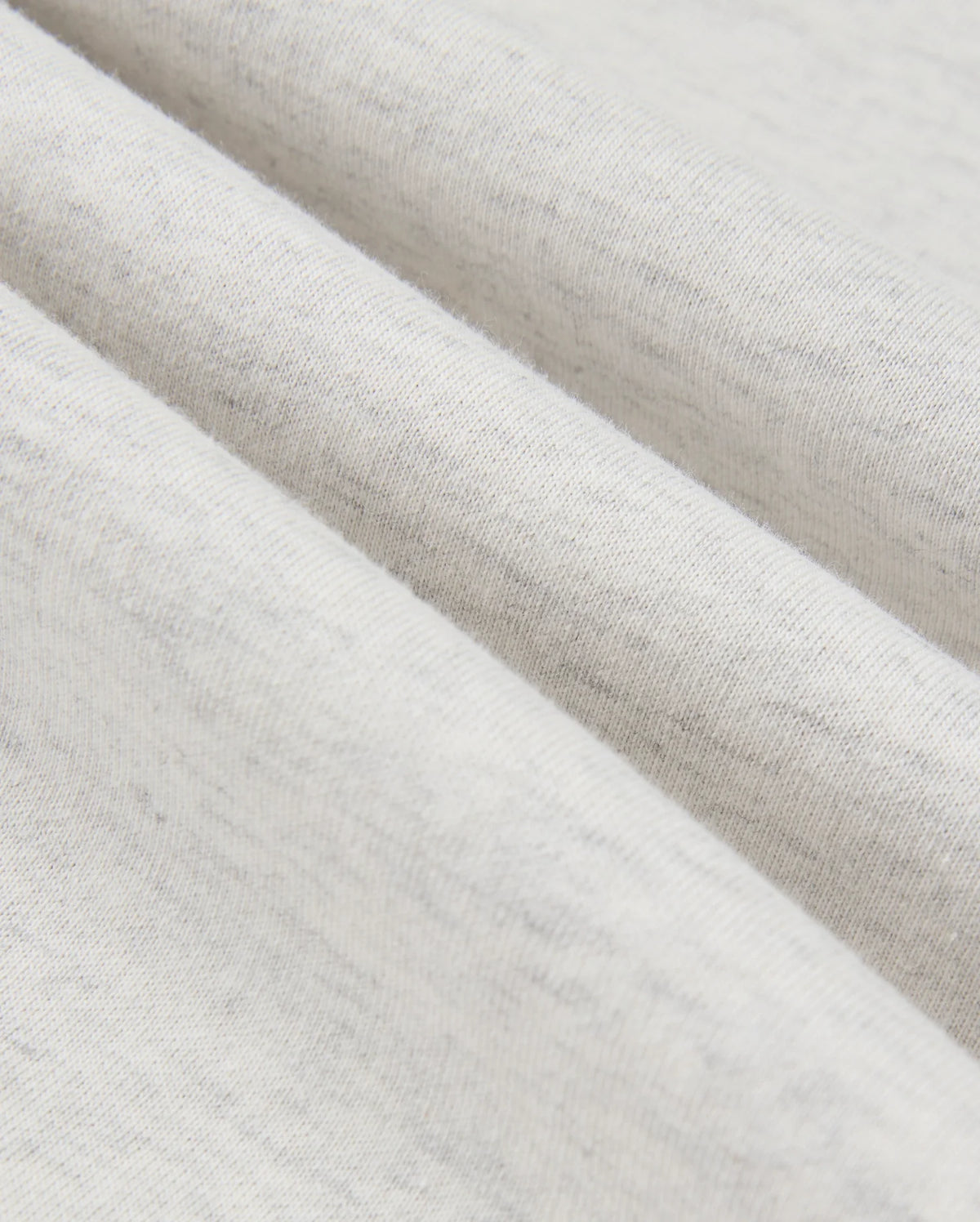 Close-up image of the Psycho Bunny MENS JAMES PREMIUM HOODIE - B6H789D200, highlighting its premium jersey fabric with a soft texture, gentle folds, and subtle gray speckles. The material looks lightweight and comfortable, promising a touch of stylish warmth.