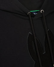 Close-up of a black Psycho Bunny Men's Pacific Chenille Hoodie, model B6H930D200, boasting drawstrings and an adorable furry rabbit ear design. A small hint of the blue tag is visible inside the neckline, adding charm to this cozy piece.