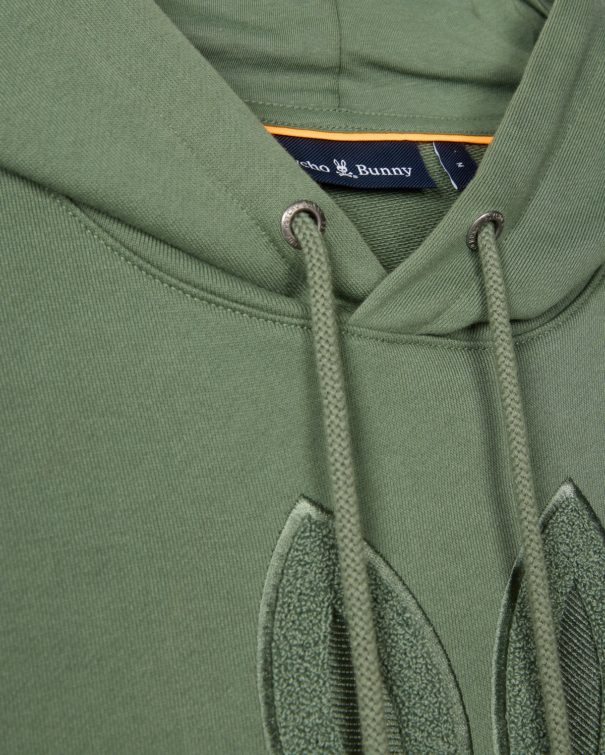 Close-up of the Psycho Bunny MENS PACIFIC CHENILLE HOODIE - B6H930D200 in green with drawstrings, showcasing a label and stitched detailing. Crafted from soft French terry, it features exquisite chenille embroidery for added texture.