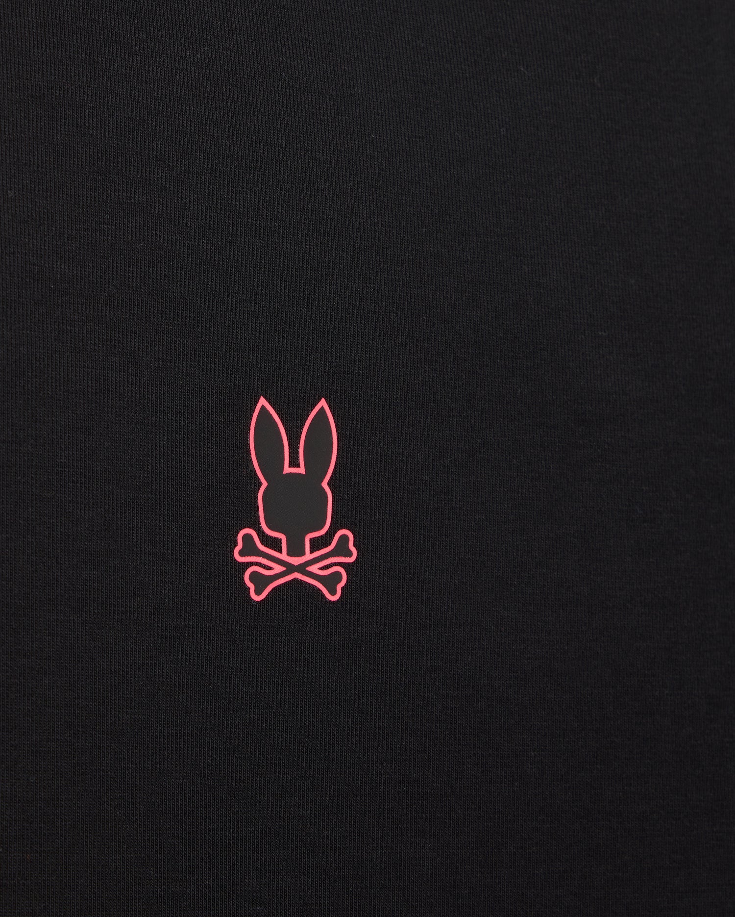 The MENS TRAVIS TRACK JACKET - B6J142D200 by Psycho Bunny is a black fabric track jacket featuring a pink lower center logo with an outline of a rabbit's head above two crossed bones. It includes invisible zip pockets for secure storage, making it ideal for everything from training to recovery.